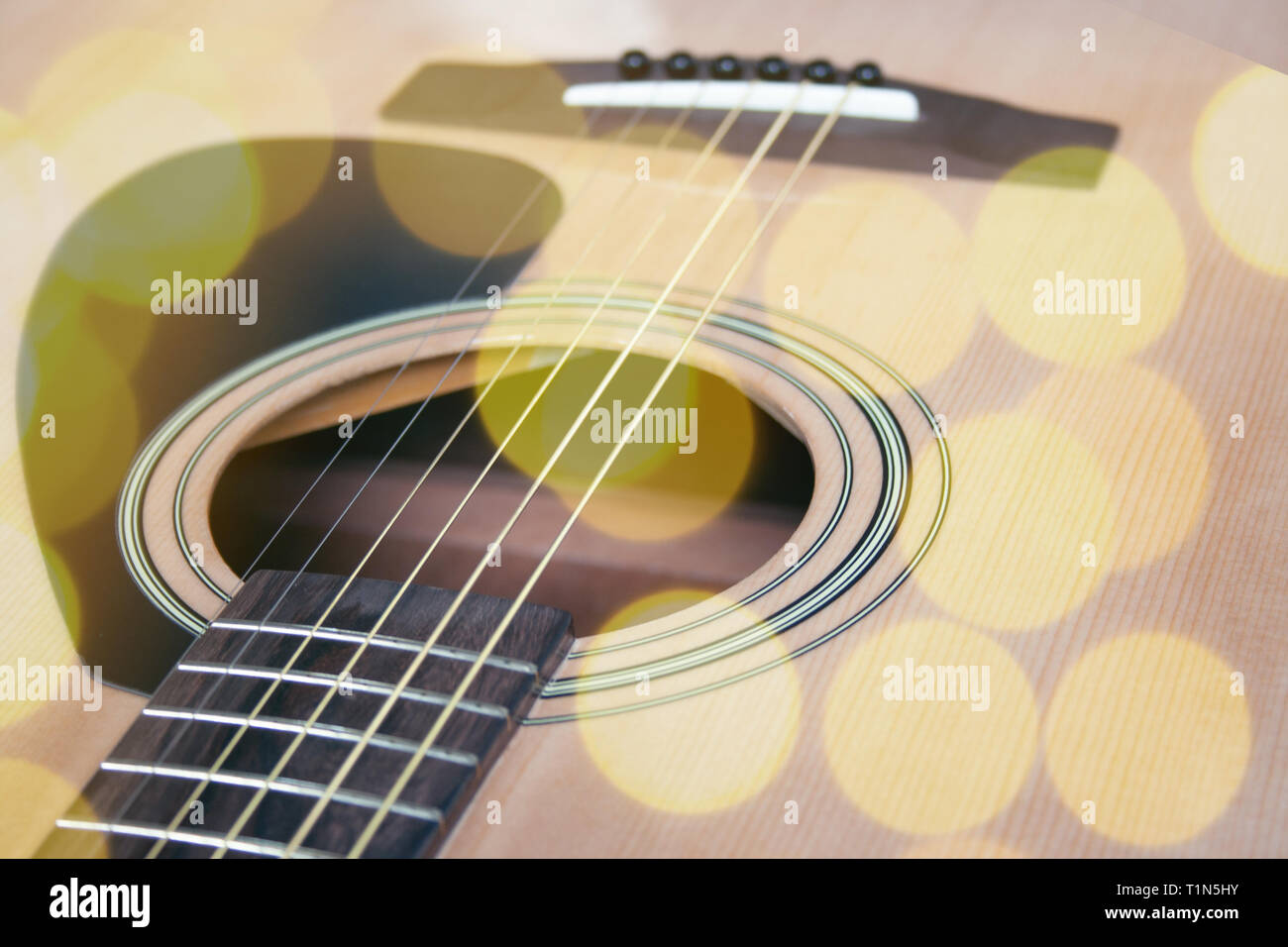 Close up di chitarra acustica con le corde di metallo. Il concetto di musica. Hobby, tempo libero concetto. Imparare a suonare la chitarra. Tonica con colori luminosi bokeh round Foto Stock