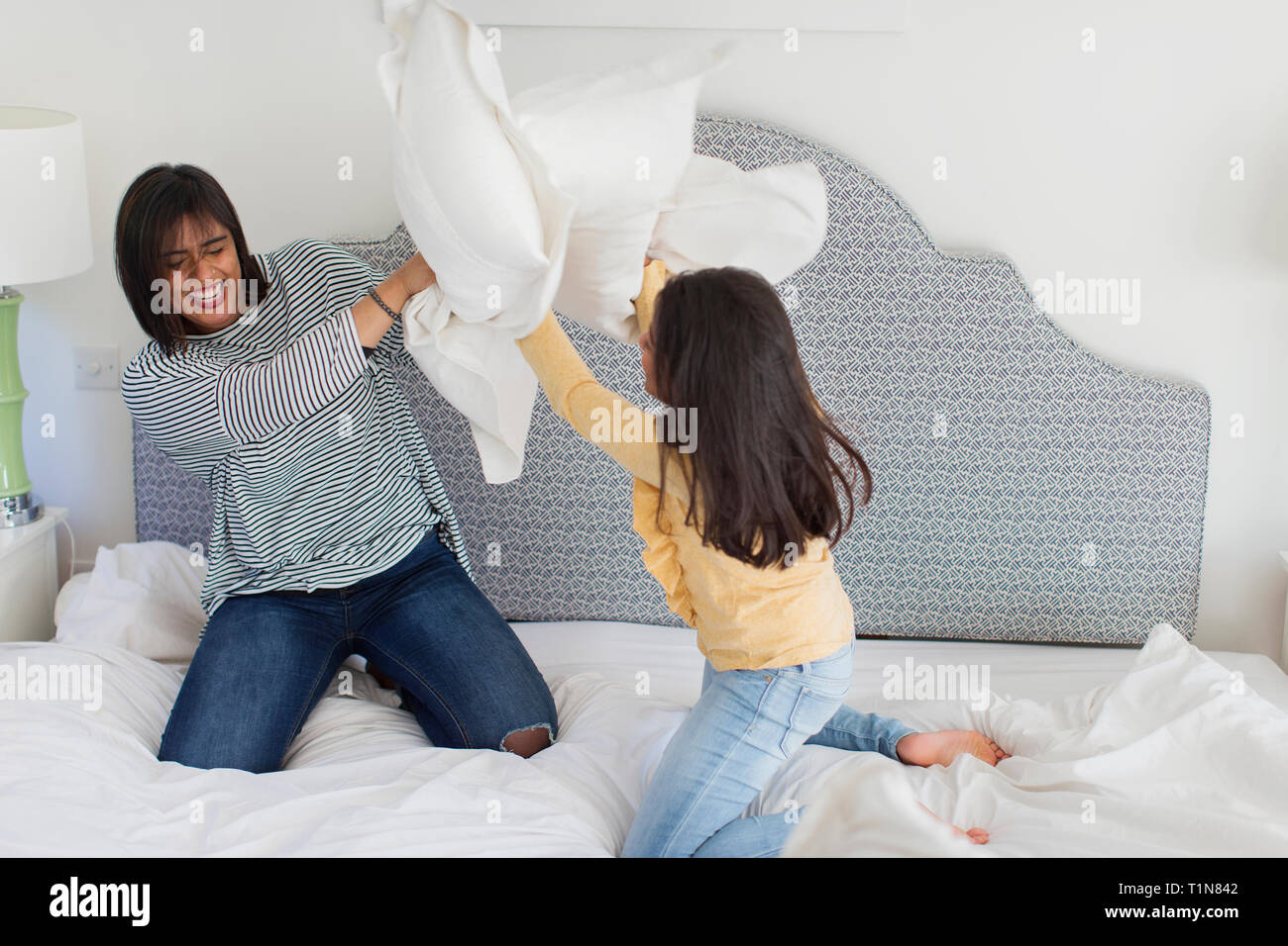 Giocoso madre e figlia godendo lotta di cuscini Foto Stock