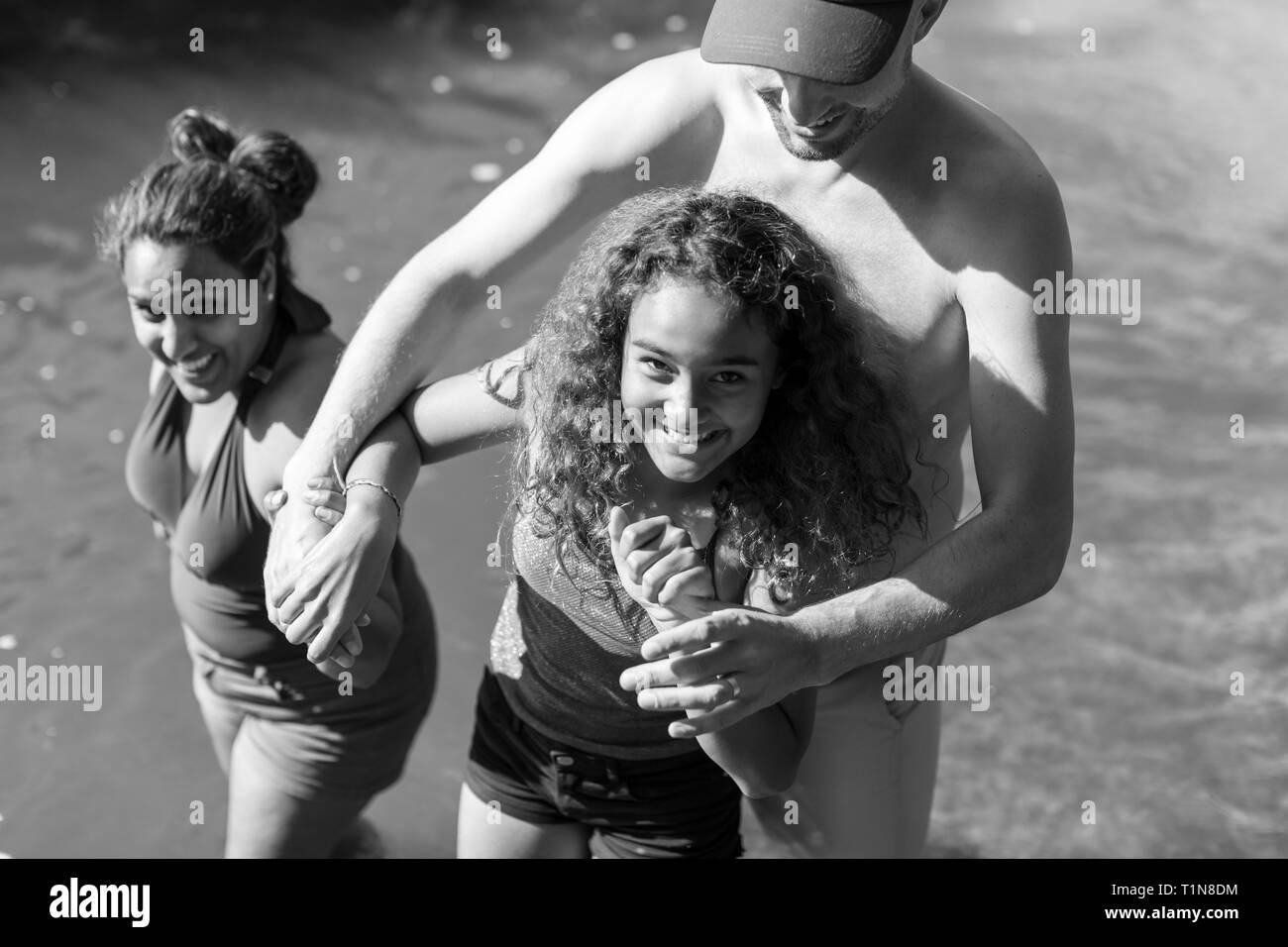 Ritratto di famiglia felice giocando nel fiume Foto Stock