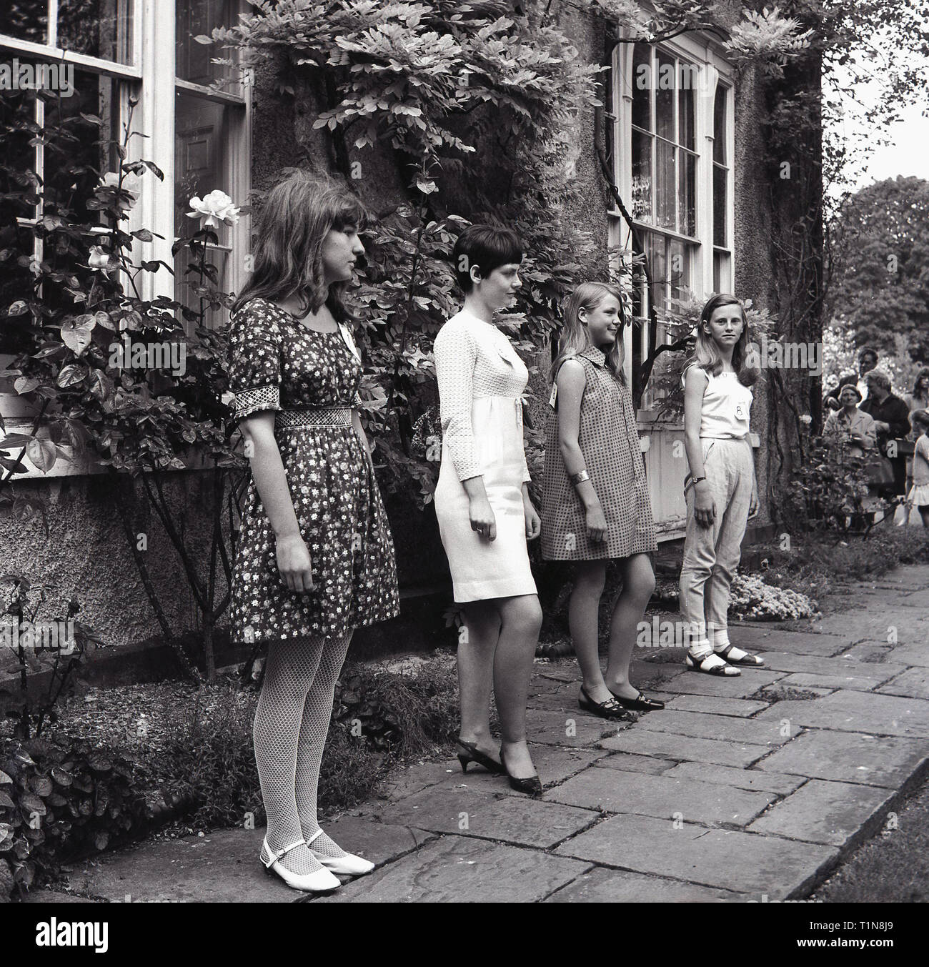 1967, ragazze in piedi al di fuori di una country house la modellizzazione della ultima moda femminile, Inghilterra, Regno Unito. Foto Stock