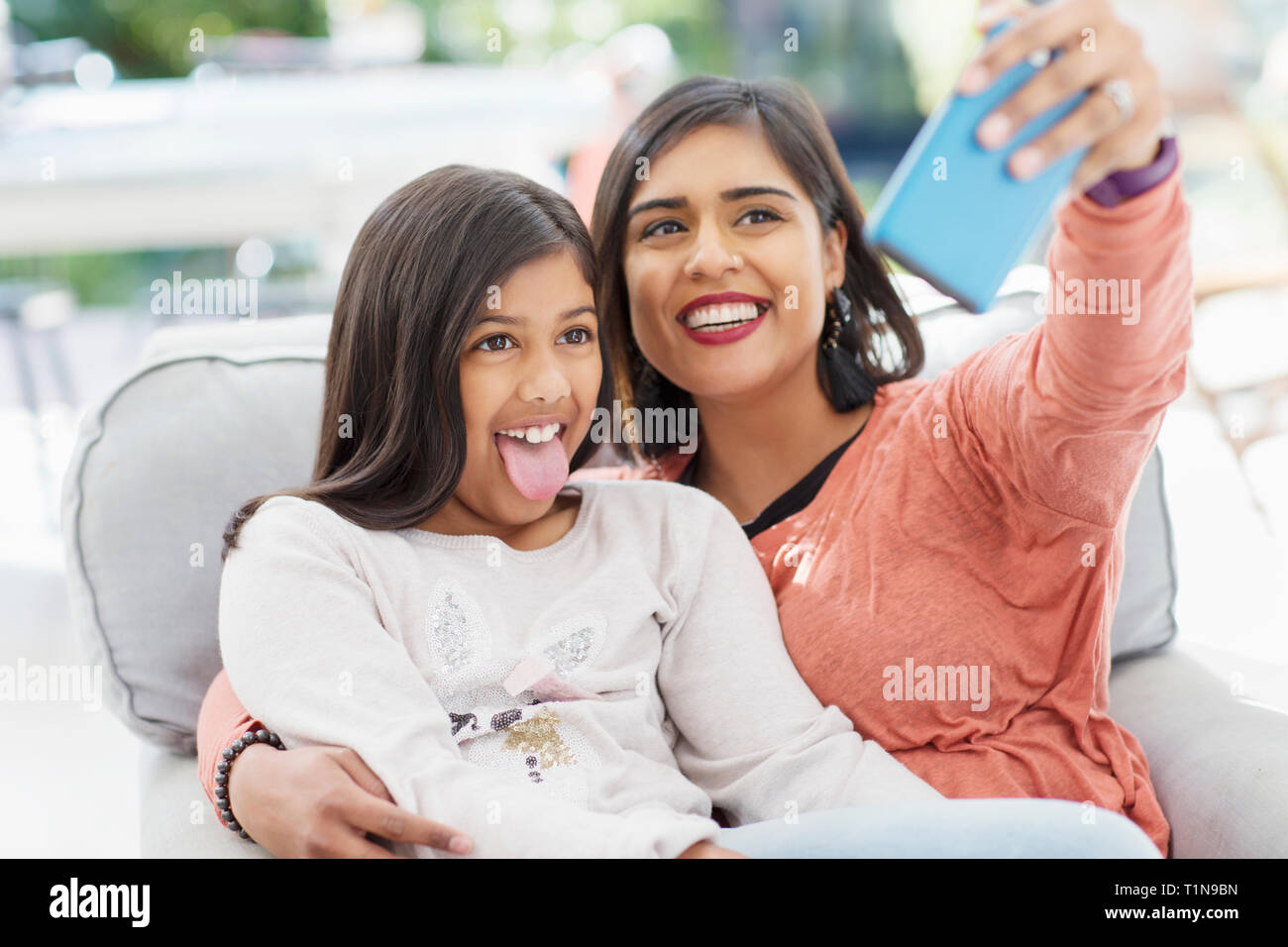 Giocoso madre e figlia tenendo selfie con la fotocamera del telefono Foto Stock