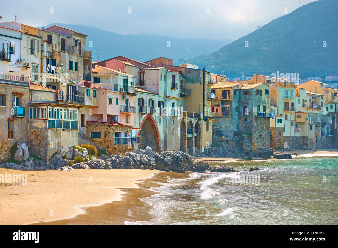 Vecchie case colorate dal mare nella città di Cefalu in Sicilia, Italia Foto Stock