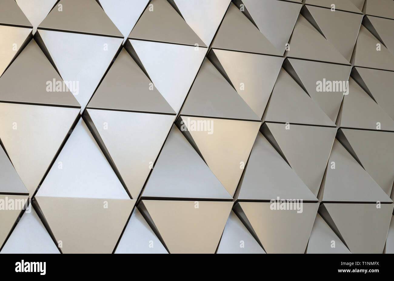 Parete futuristico di sollievo triangoli metallici. 3d sfondo geometrico. Foto Stock