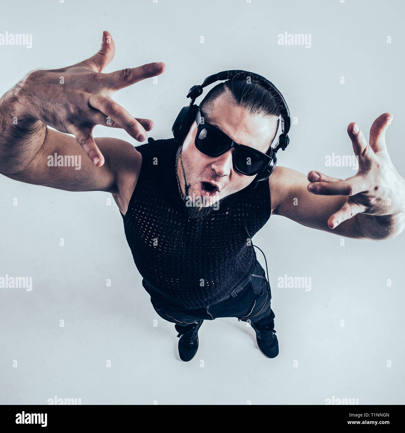 Vista dall'alto - DJ - rapper con cuffie su uno sfondo luminoso Foto Stock
