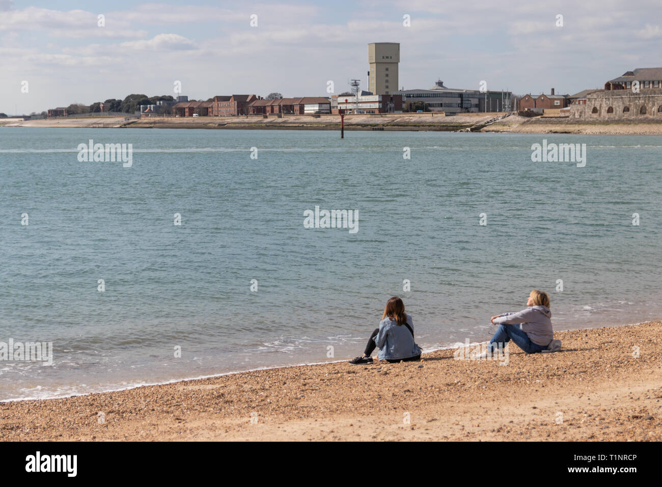 Madre e figlia godendo il sole sulla spiaggia a Old Portsmouth spiaggia ghiaiosa Foto Stock