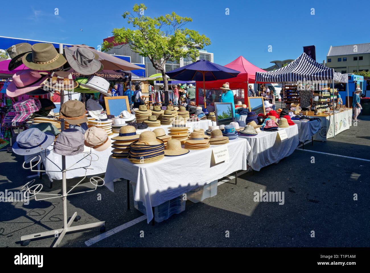 Pile di cappelli di paglia su un mercato di Nelson stallo in una giornata di sole. Nelson, Nuova Zelanda. Foto Stock