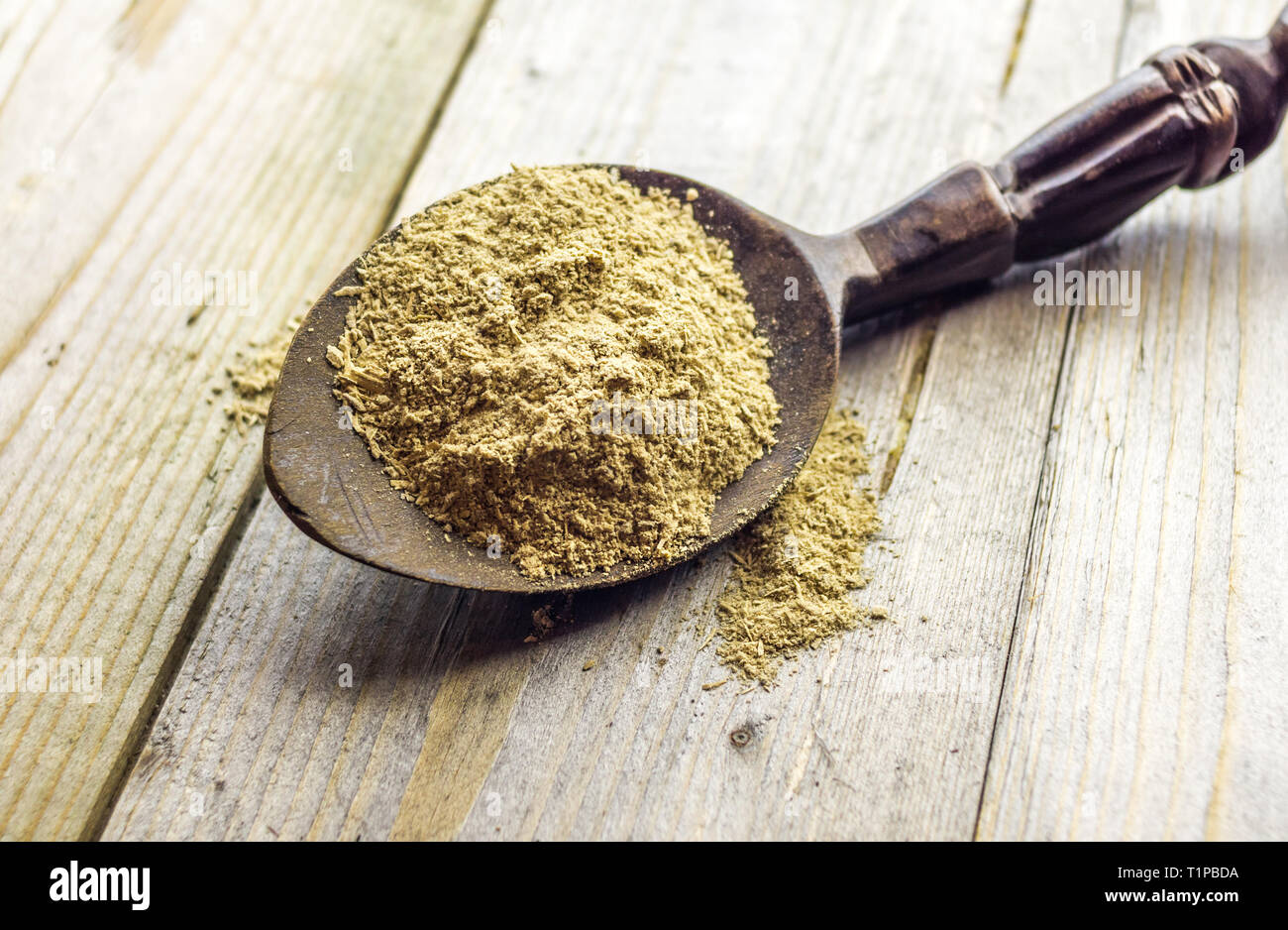 Cucchiaio con la Kava Kava radice in polvere sul tavolo di legno Foto Stock