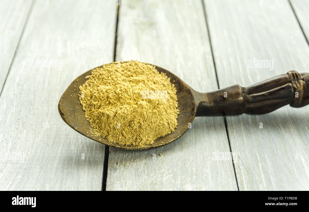 Cucchiaio con la Kava Kava radice in polvere sul tavolo di legno Foto Stock