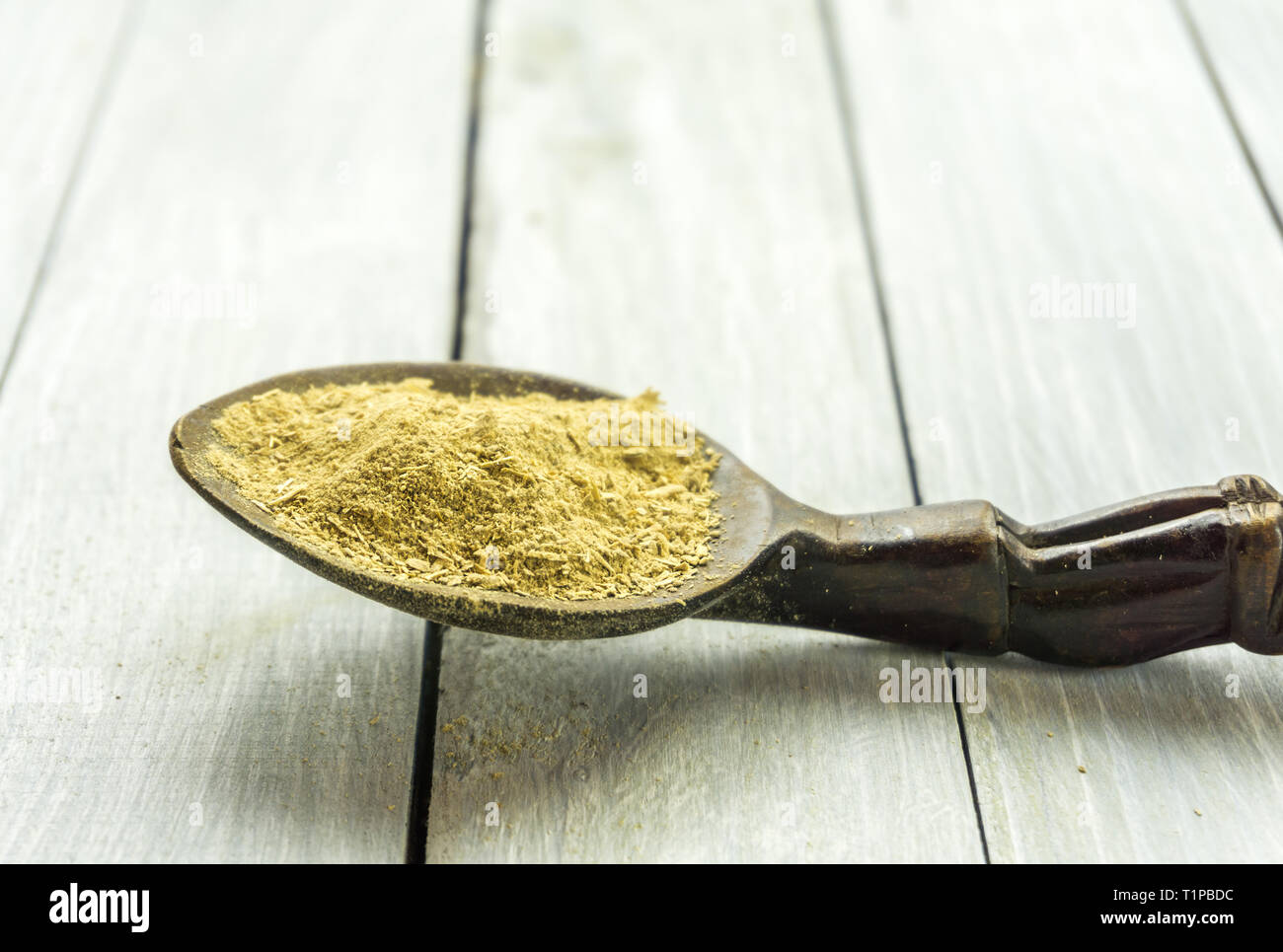 Cucchiaio con la Kava Kava radice in polvere sul tavolo di legno Foto Stock