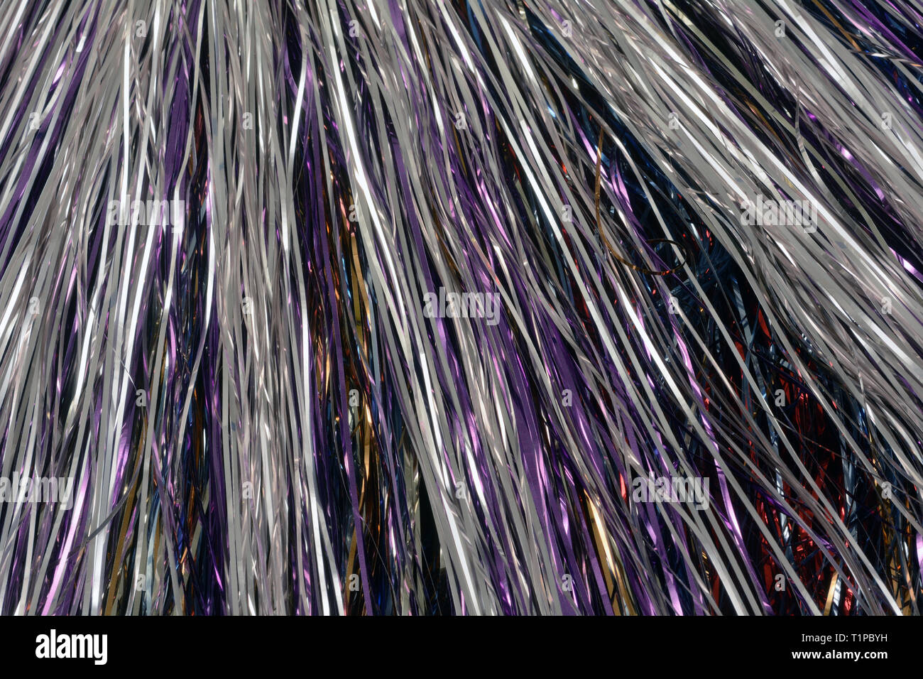 Abstract festosa celebrazione viola e argento streamer tinsel metallico sullo sfondo Foto Stock