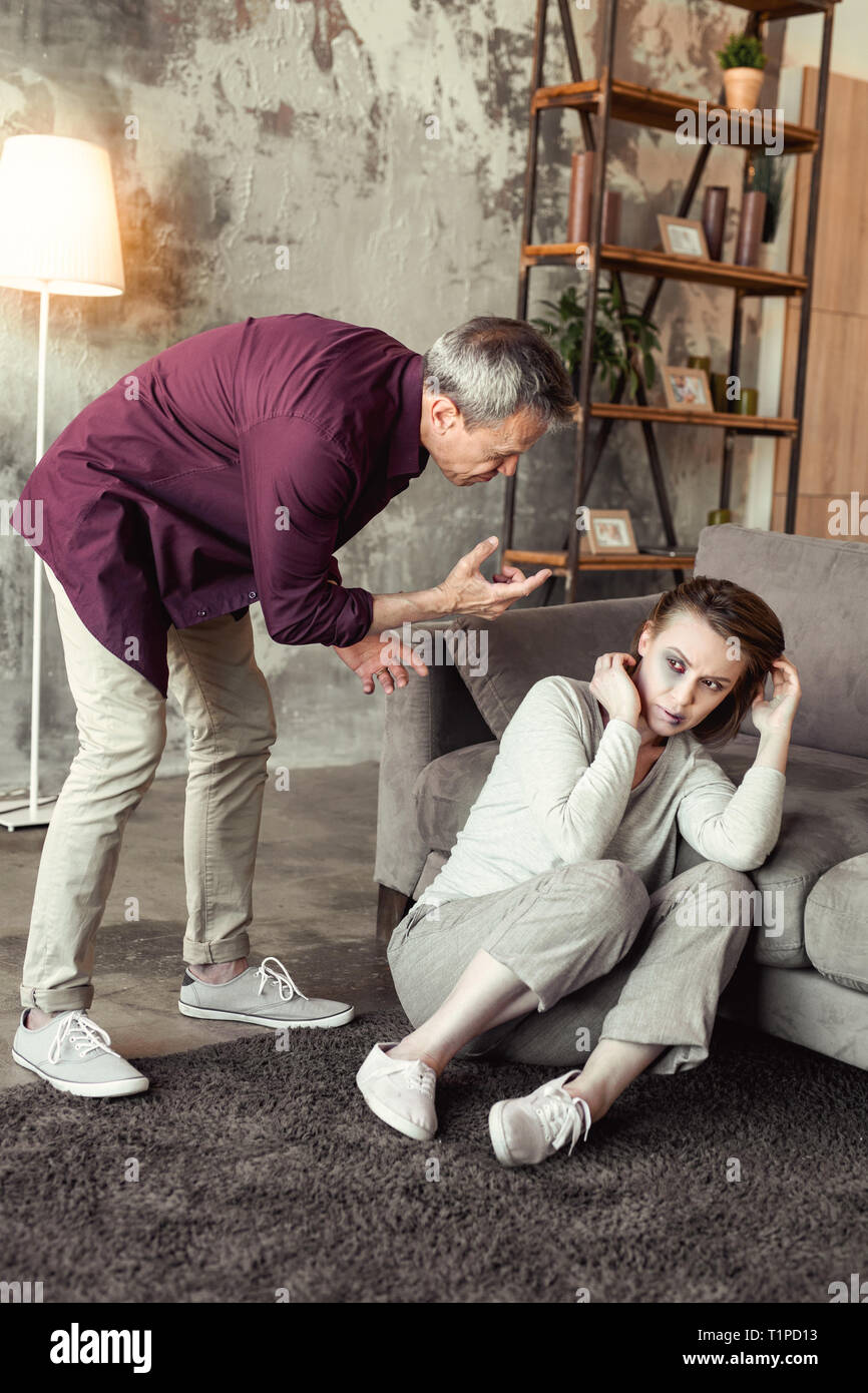 Grigio-dai capelli uomo vecchio urla sulla paura moglie mentre è ubriaco e mad Foto Stock