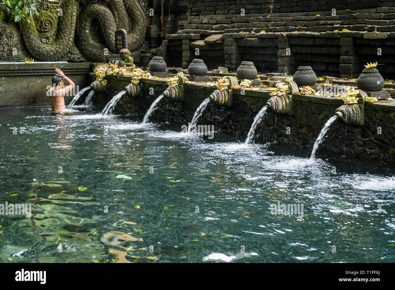 Bali, Indonesia - 22 gennaio 2019: il giovane uomo che prega nella primavera sacra di acqua pura Tirta Empul temple a Tampa, Bali, Indonesia. Foto Stock