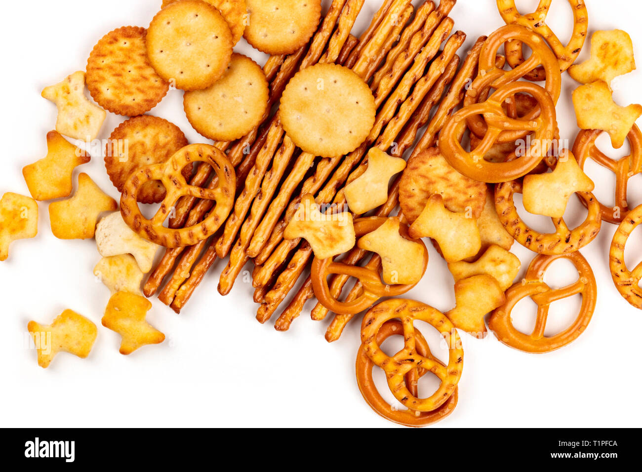 Varie cracker salato, bastoncini, salatini e goldfishes, ripresa dall'alto su uno sfondo bianco con copia spazio. Party Mix snack banner Foto Stock