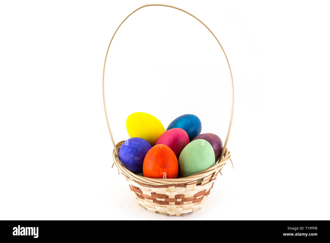 Colorfull uova di Pasqua nel cesto di vimini isolati su sfondo bianco Foto Stock