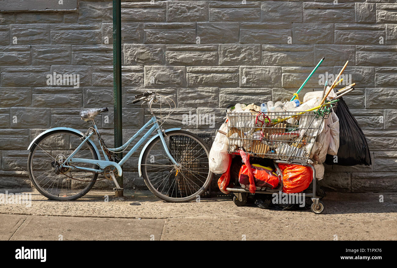 Vecchia moto e carrello riempito di immondizia su una strada di New York City, Stati Uniti d'America. Foto Stock