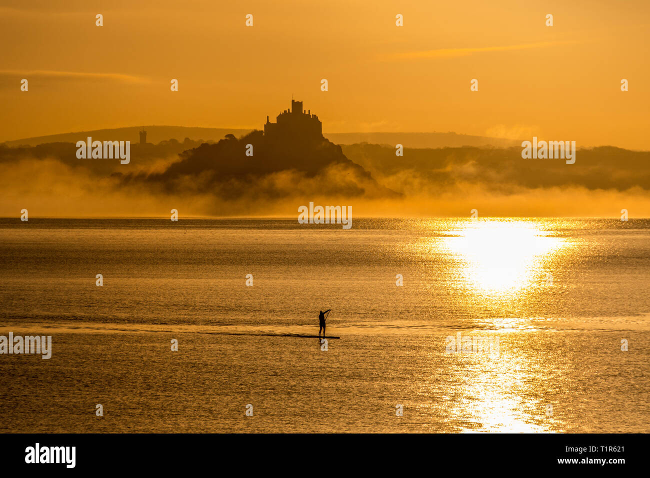 Penzance, Cornwall, Regno Unito. 28 Mar, 2019. Regno Unito Meteo. Paddleboarders erano fuori a 5am questa mattina per renderlo in tutto il mare a Mounts Bay per il tramonto su St Michaels Mount. Credito: Simon Maycock/Alamy Live News Foto Stock