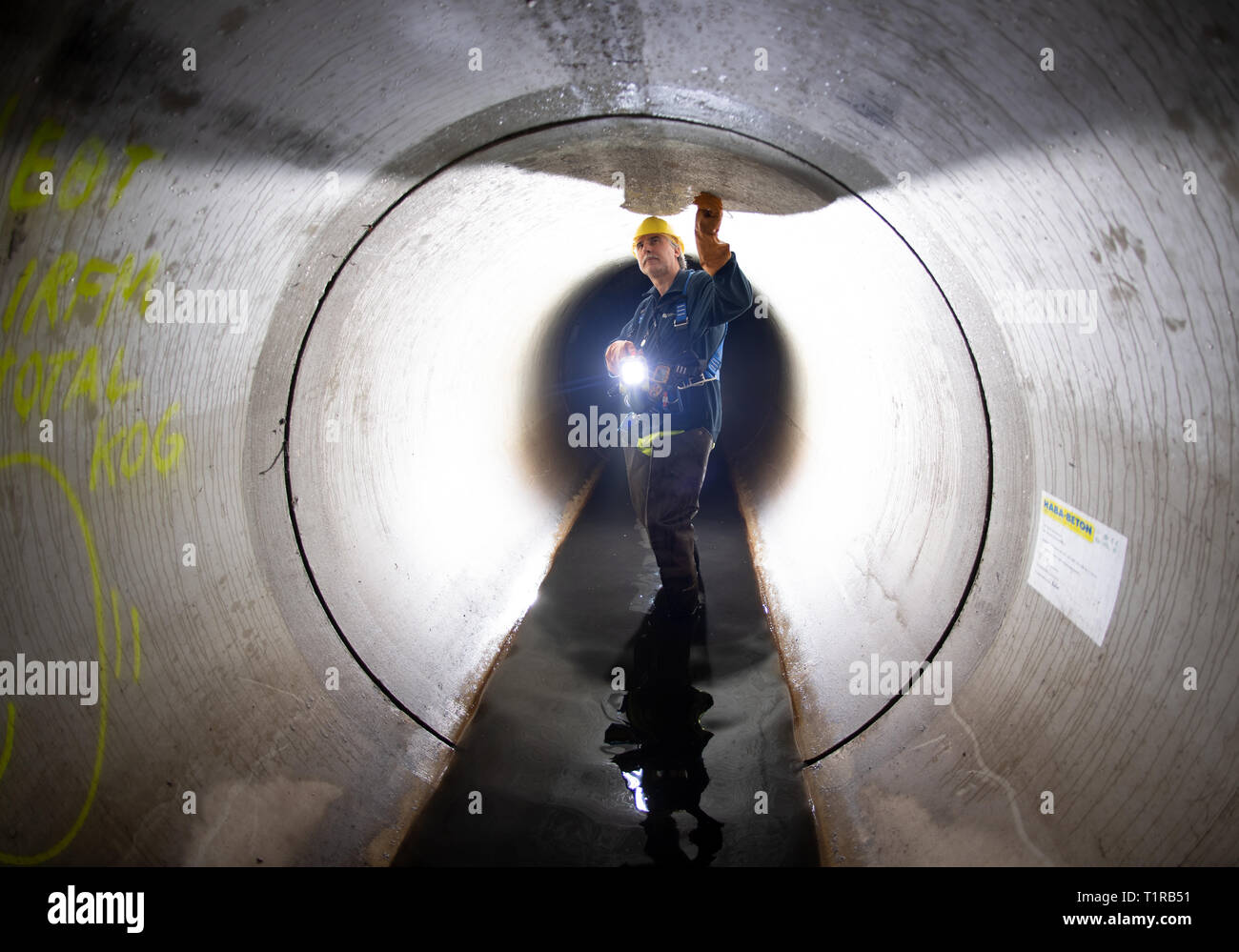 Berlino, Germania. 28 Mar, 2019. Durante un evento stampa della Berliner Wasserbetriebe in Berlin-Friedenau, un lavoratore guarda a parte di un nuovo, a circa due chilometri di canale di acqua sotterranea. Questo canale può assumere e scarica in modo sicuro circa 3500 metri cubi di acque reflue e fa parte di una nuova costruzione e programma di rinnovo dell'acqua utilities con investimenti di circa 21 milioni di euro. Credito: Ralf Hirschberger/dpa/Alamy Live News Foto Stock