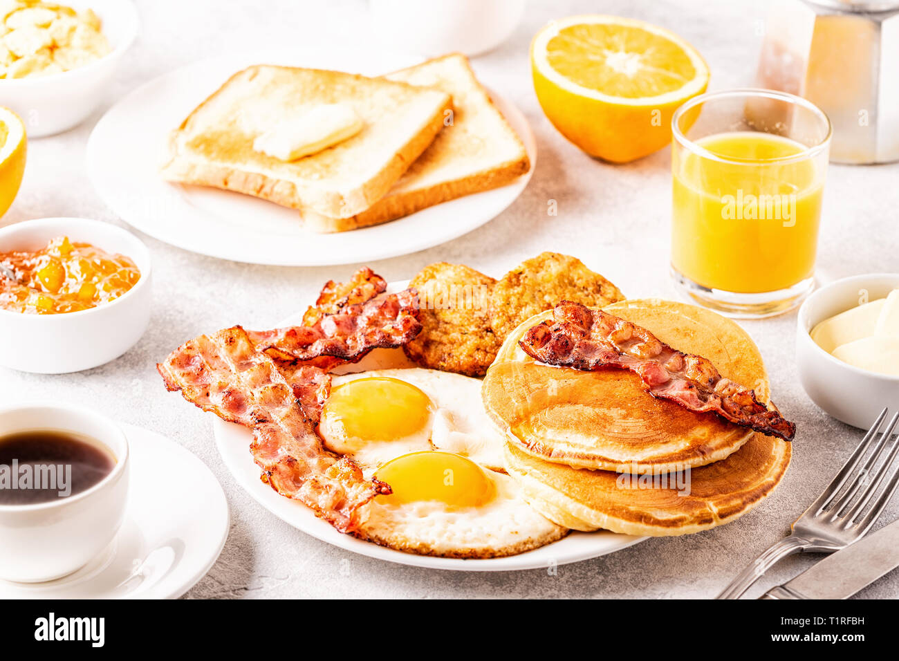 Una sana colazione Americana completa con uova pancetta pancake e Latkes, il fuoco selettivo. Foto Stock