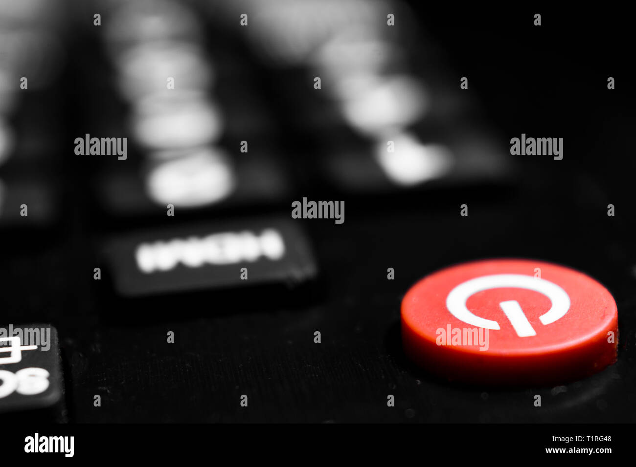 Un primo piano per il pulsante rosso di accensione del telecomando per telecontrollo con effetto bokeh di fondo Foto Stock