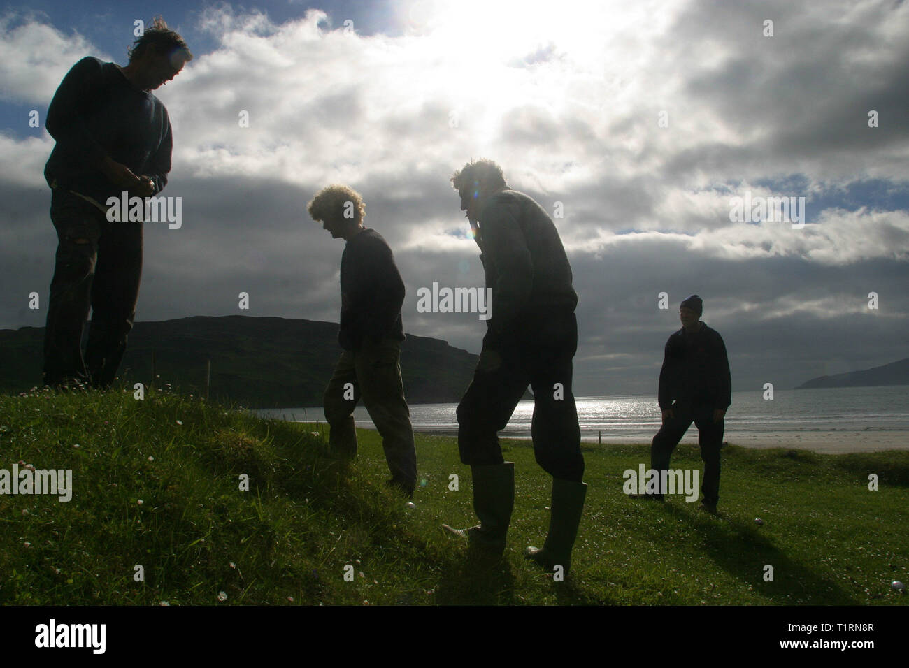 Isolani giocando a bocce sulla spiaggia di Baia di Laig sull'isola delle Ebridi di Eigg. L'isola di Eigg era uno di una catena di isole che si trovano di la costa ovest della Scozia ed era accessibile da parte di uno Stato-run lifeline servizio dalla terraferma. I residenti su Eigg organizzato un buy-out dell'isola alla fine degli anni novanta e ha preso nelle proprietà della Comunità. Foto Stock