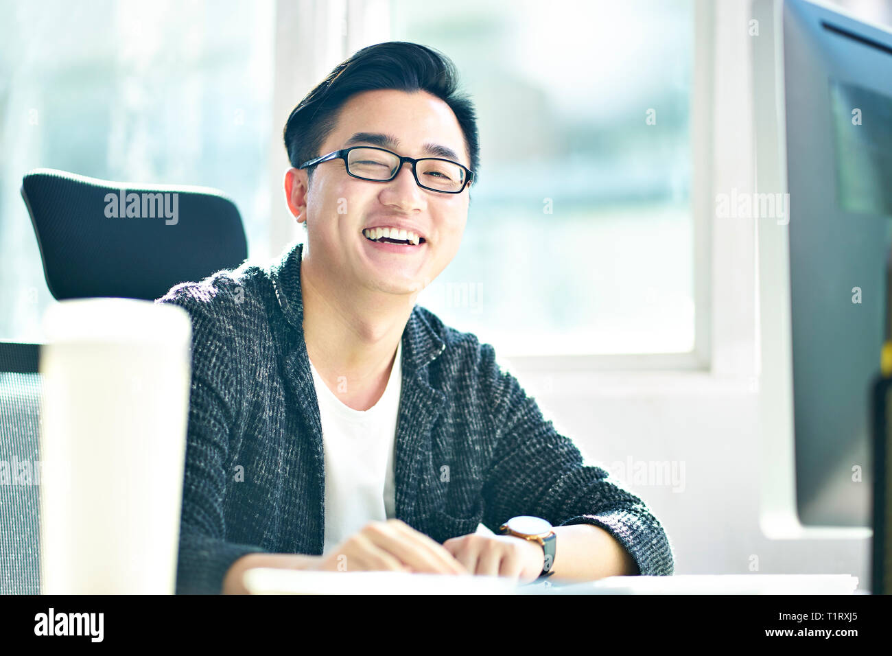 Ritratto di successo di affari asiatici uomo che lavora in ufficio guardando sorridente della fotocamera Foto Stock