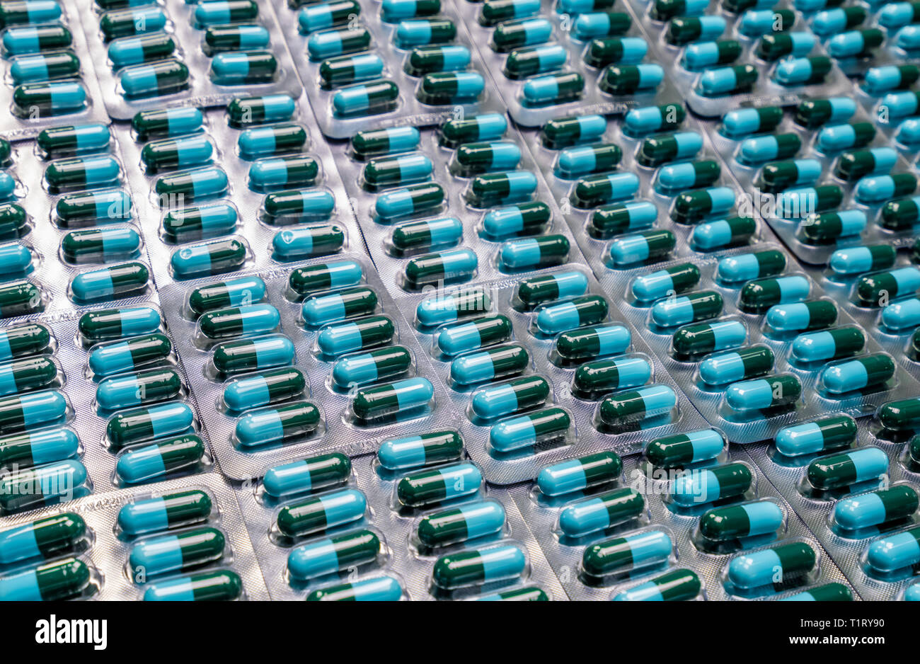 Primo piano verde-blu capsula di antibiotico pillole in confezione blister. Farmaco antimicrobico resistenza. Industria farmaceutica. Global Healthcare. Farmacia backg Foto Stock