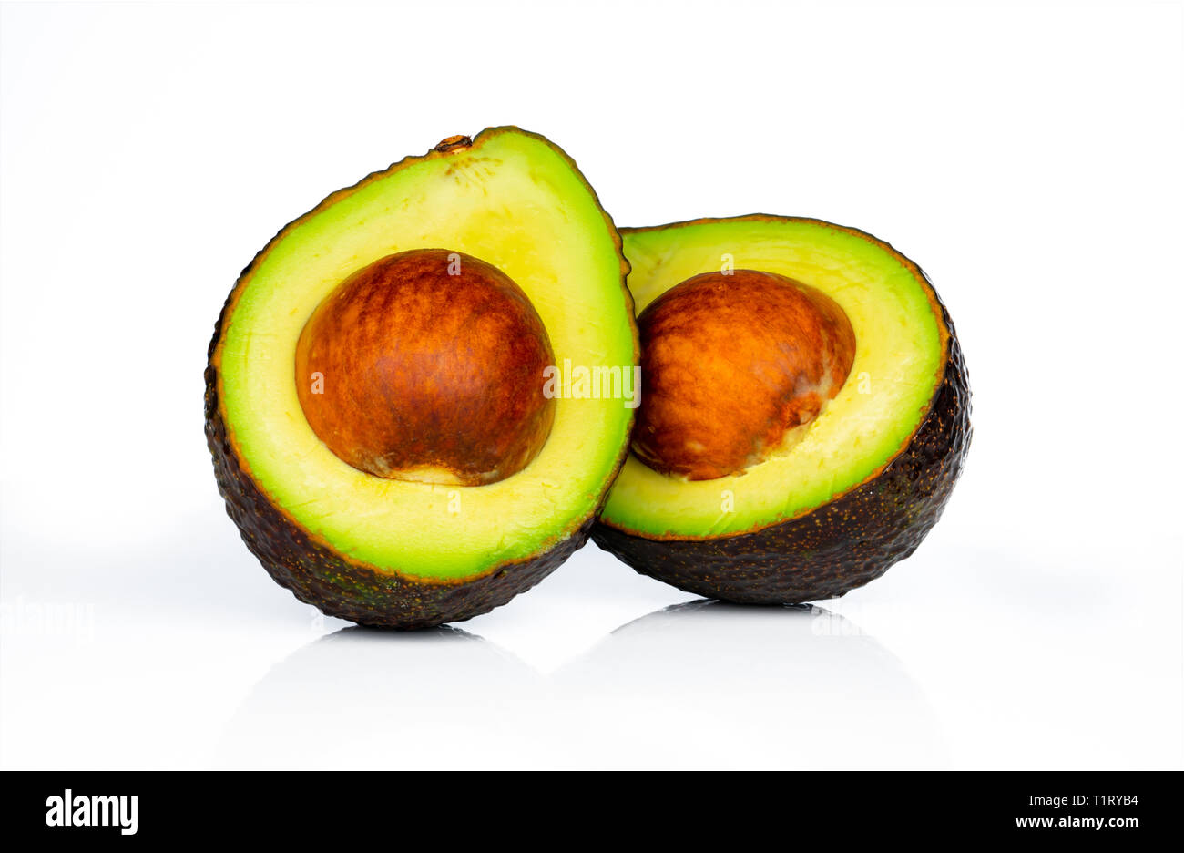 Avocado con sementi isolati su sfondo bianco. Fonte di omega 3 da alimenti naturali. Cibo sano per il bambino. La metà dei pezzi di avocadi disposti con beau Foto Stock