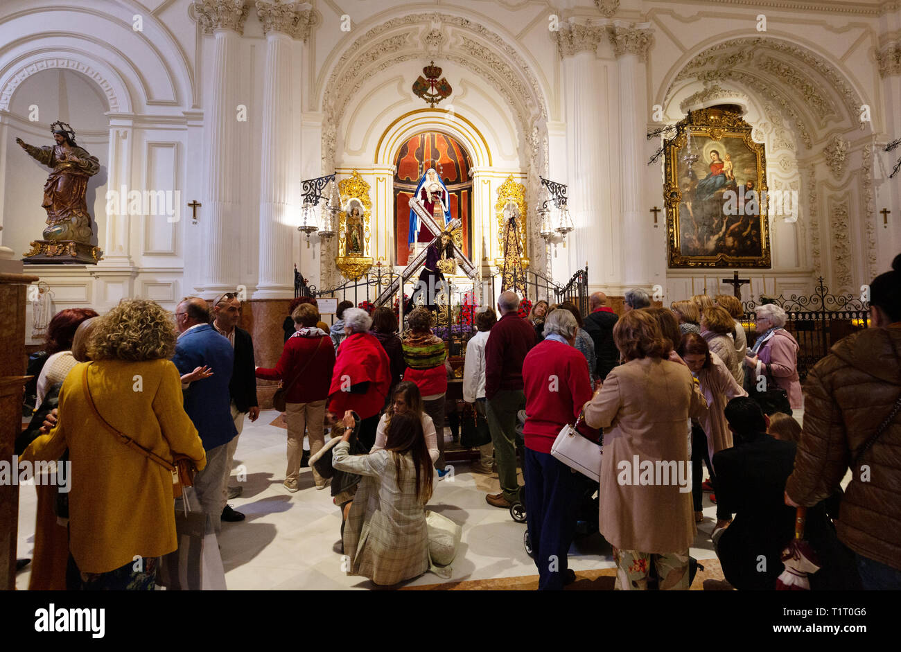 La gente in una cappella, interno della Iglesia de Santiago (Chiesa di Santiago), la più antica chiesa cattolica romana a Malaga, Andalusia Spagna Europa Foto Stock