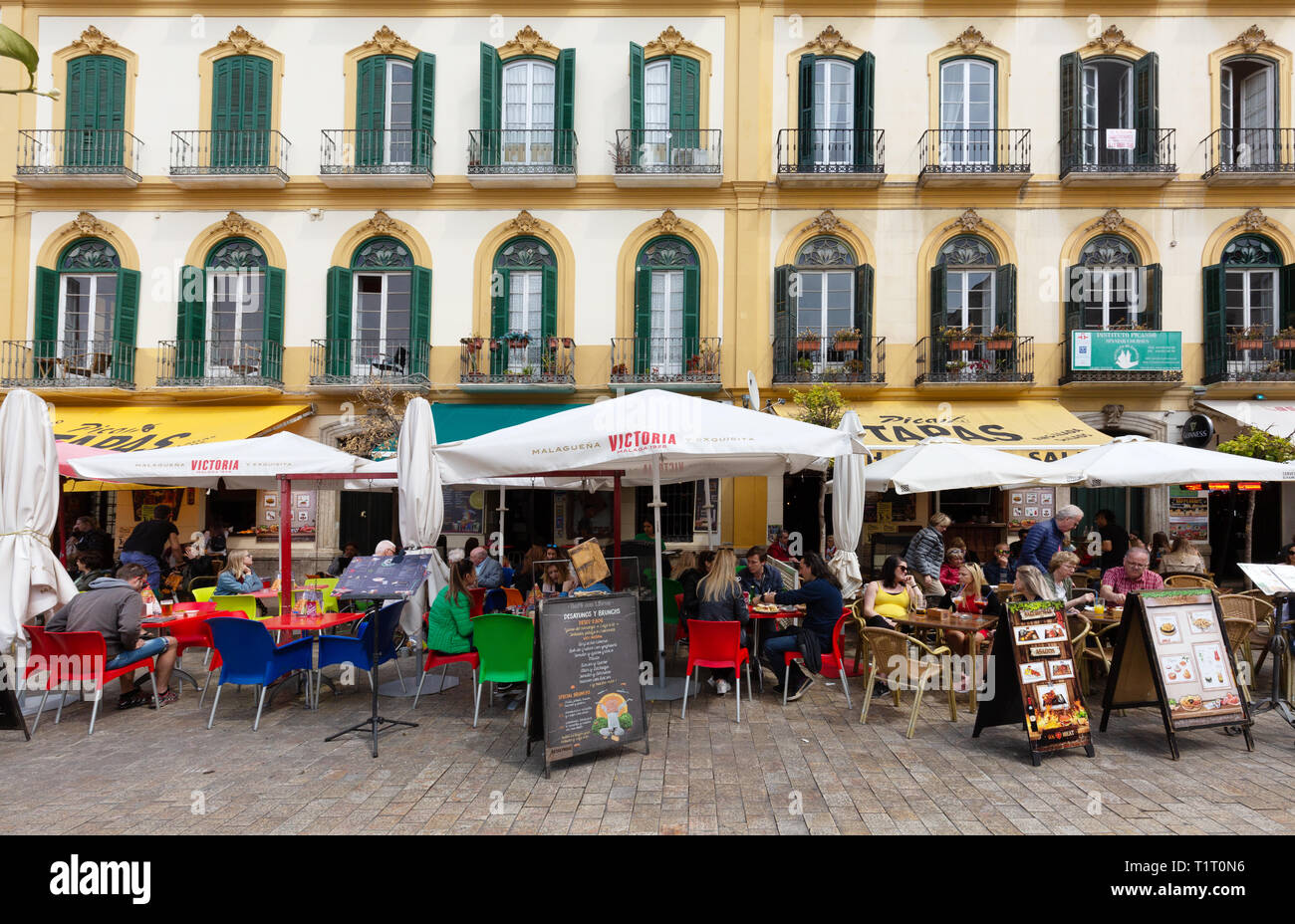 Malaga Spagna - persone che siedono al Tapas bar mangiare tapas fuori; Plaza de la Merced, Malaga Andalusia Spagna Europa Foto Stock
