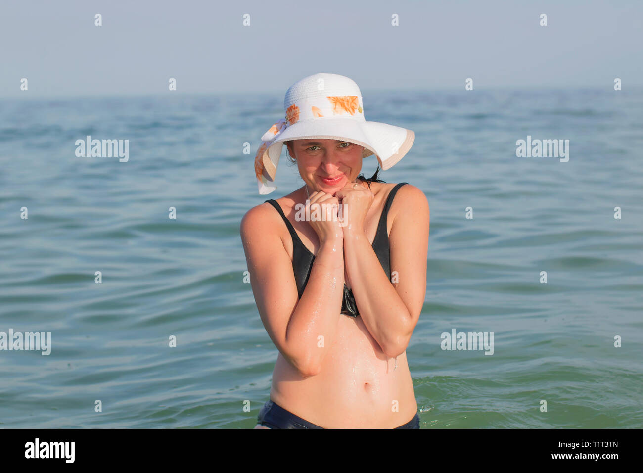 Una donna di mezza età hat in bikin in mare Foto Stock