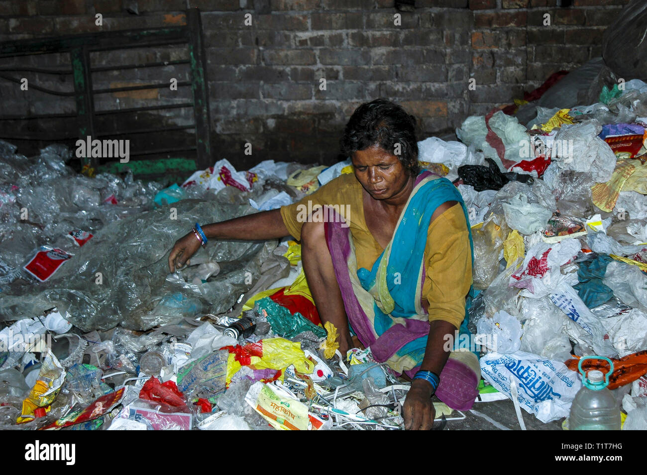 Donna riciclaggio dei materiali in plastica nella baraccopoli di Kolkata Foto Stock