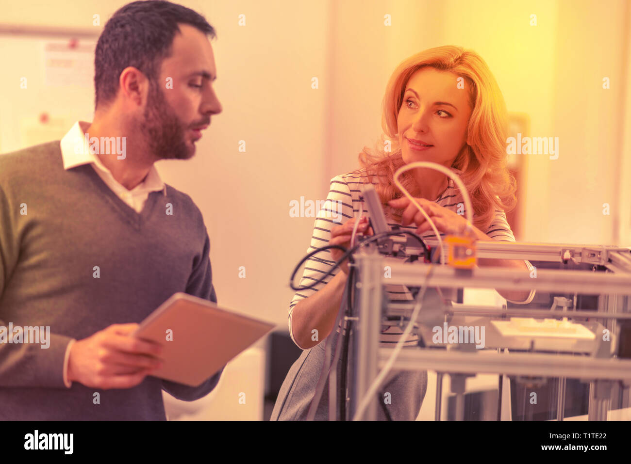 Laboriosa colleghi consulting circa l'installazione di una stampante 3D. Foto Stock