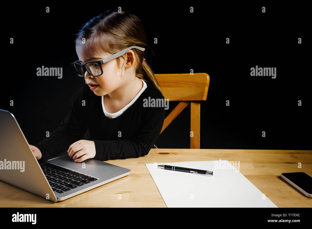 Bambina giocando in ufficio con un computer Foto Stock