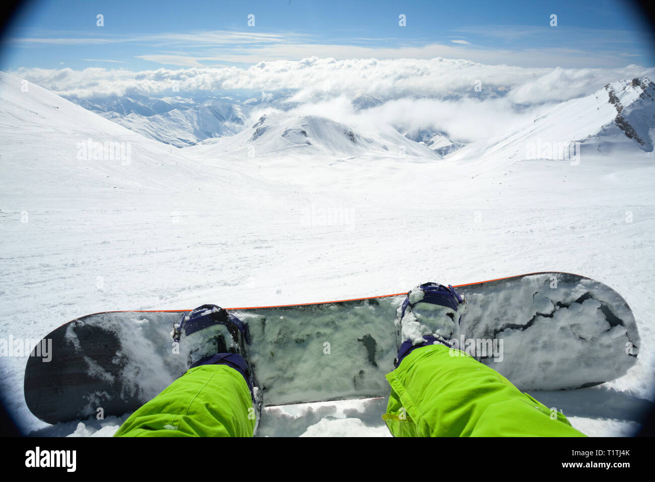 Punto di vista colpo di un maschio di snowboarder giacente sulla neve sul pendio rilassante dopo equitazione Foto Stock