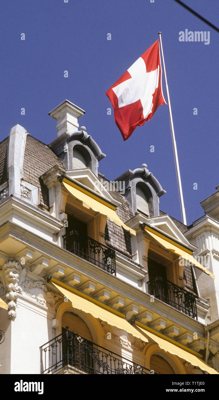 Zurigo Svizzera bandiera svizzera in pole nella parte superiore di un edificio Foto Stock