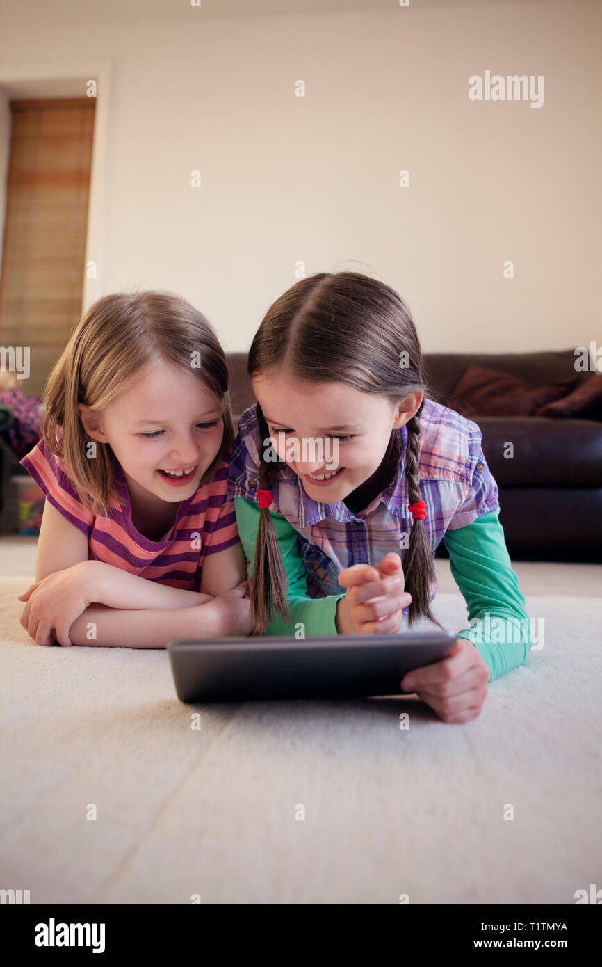 Due bambini felici utilizzando un dispositivo tablet pc insieme Foto Stock