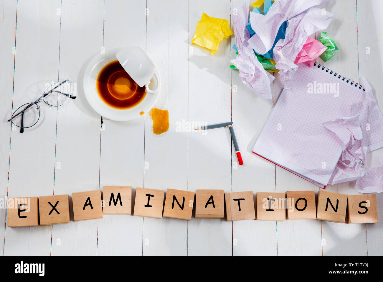 Articoli di cancelleria e esami di parola fatta di lettere sullo sfondo di legno. Istruzione, college, scuola, stress, università, studenti che studiano concetto. Appartamento laici o vista superiore Foto Stock