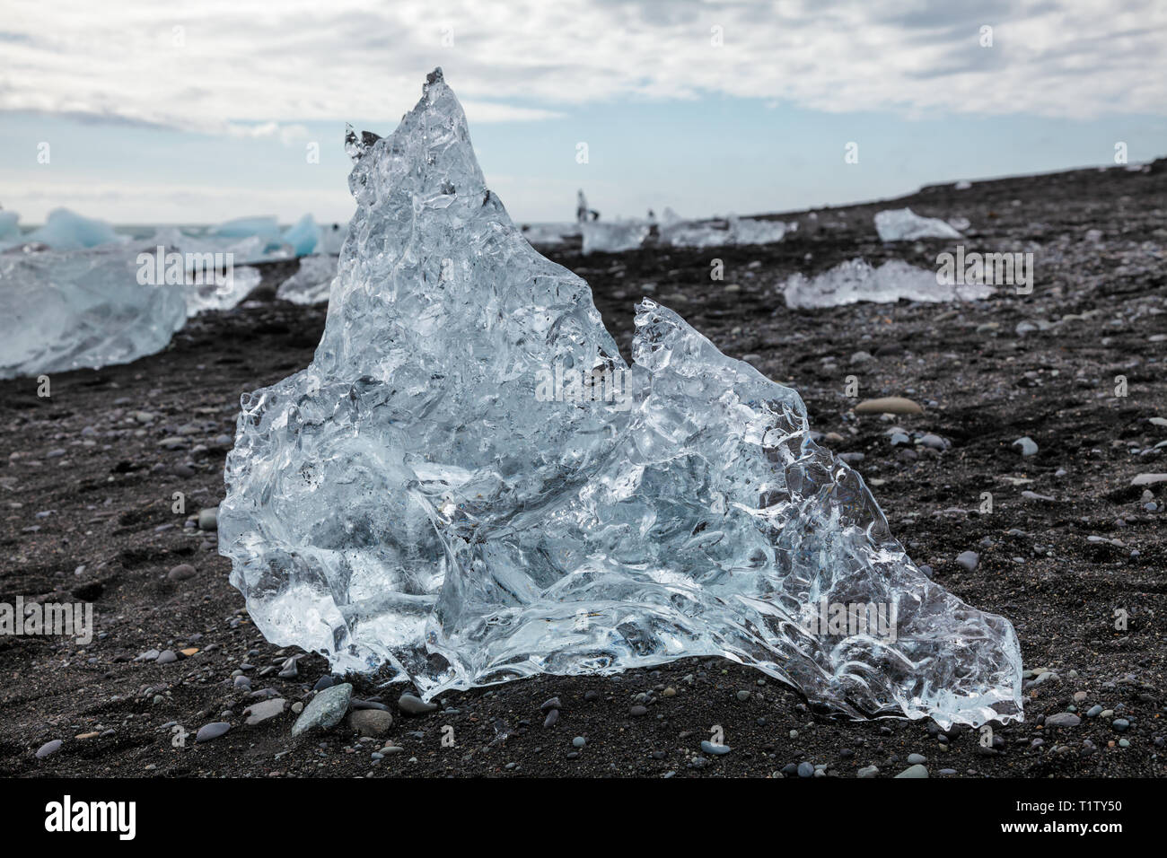 Isolato di fusione iceberg sulla spiaggia di sabbia nera vicino a Jokulsarlon laguna glaciale, un popolare dastination di viaggio e una delle meraviglie naturali dell'Islanda, Foto Stock