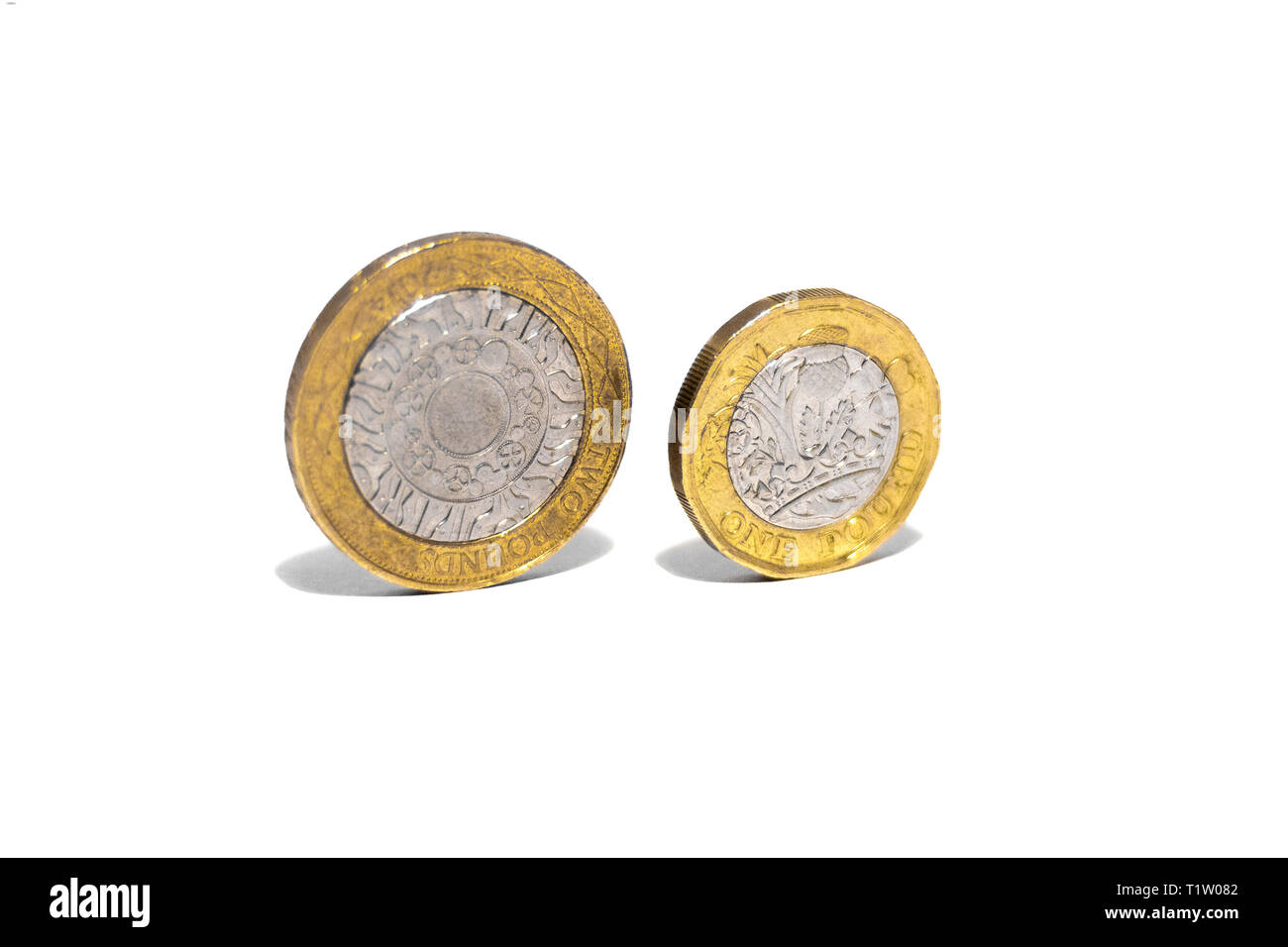 Nuovo grande sterlina GBP monete posa casualmente sulla sommità del portafoglio nero su sfondo bianco. Ricchezza, denaro contante, modificare. Foto Stock