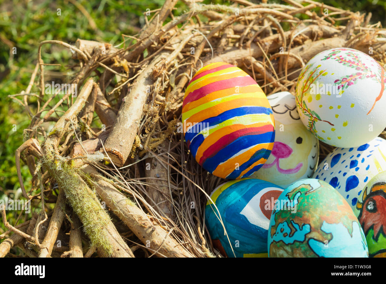 Dettaglio del dipinto di uova di pasqua con diverse forme, cartoni animati  e colori luminosi collocati in un nido di uccelli all'aperto in una  giornata di sole Foto stock - Alamy