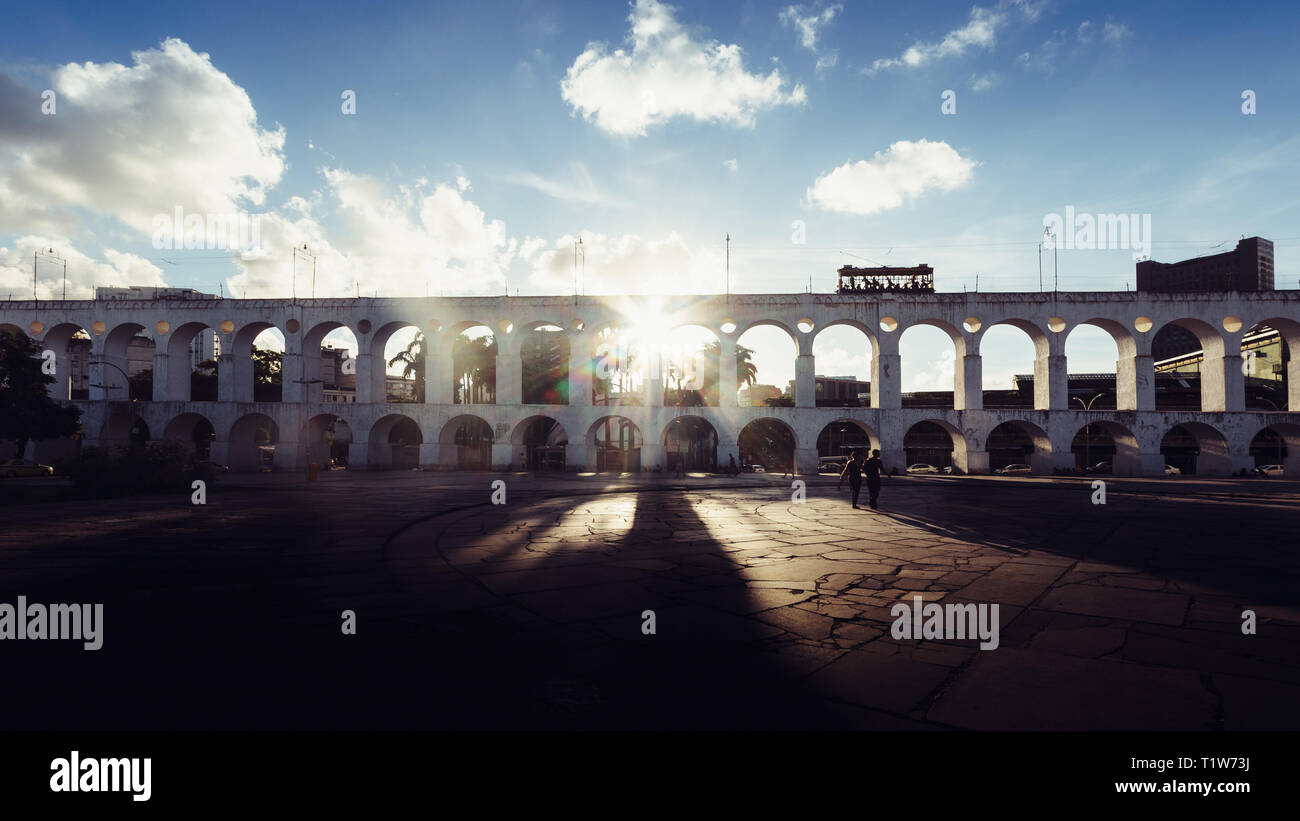 Coloniali del XIX secolo archi di Lapa, Rio de Janeiro, Brasile - La retroilluminazione con raggi del sole proveniente attraverso una delle aperture Foto Stock