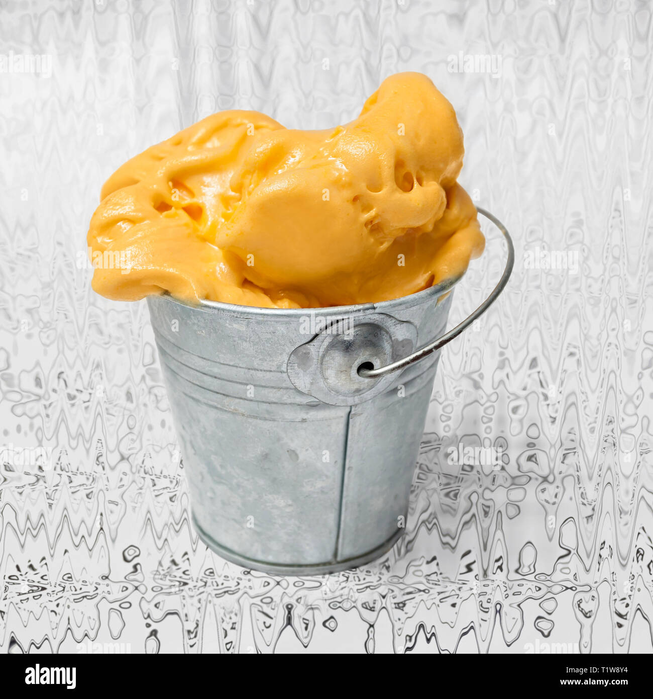 Gelato al mango in un metallo mini benna su sfondo astratto Foto Stock