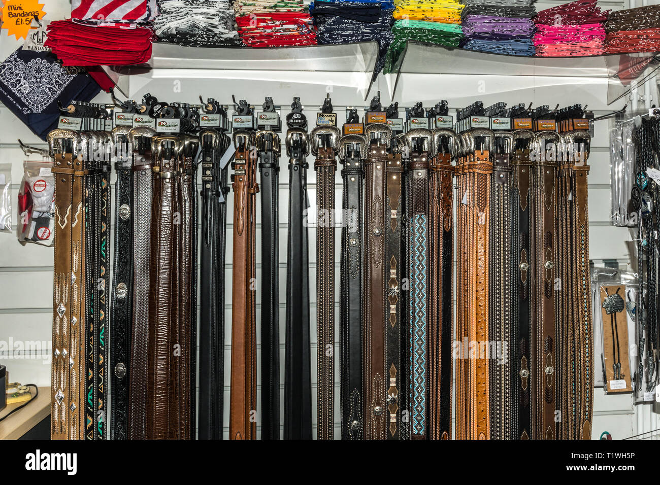 Interno della Wild Wild Western usura negozio specializzato in Farnborough, Hampshire, Regno Unito. Display del cowboy cinture e altri accessori per la vendita. Foto Stock