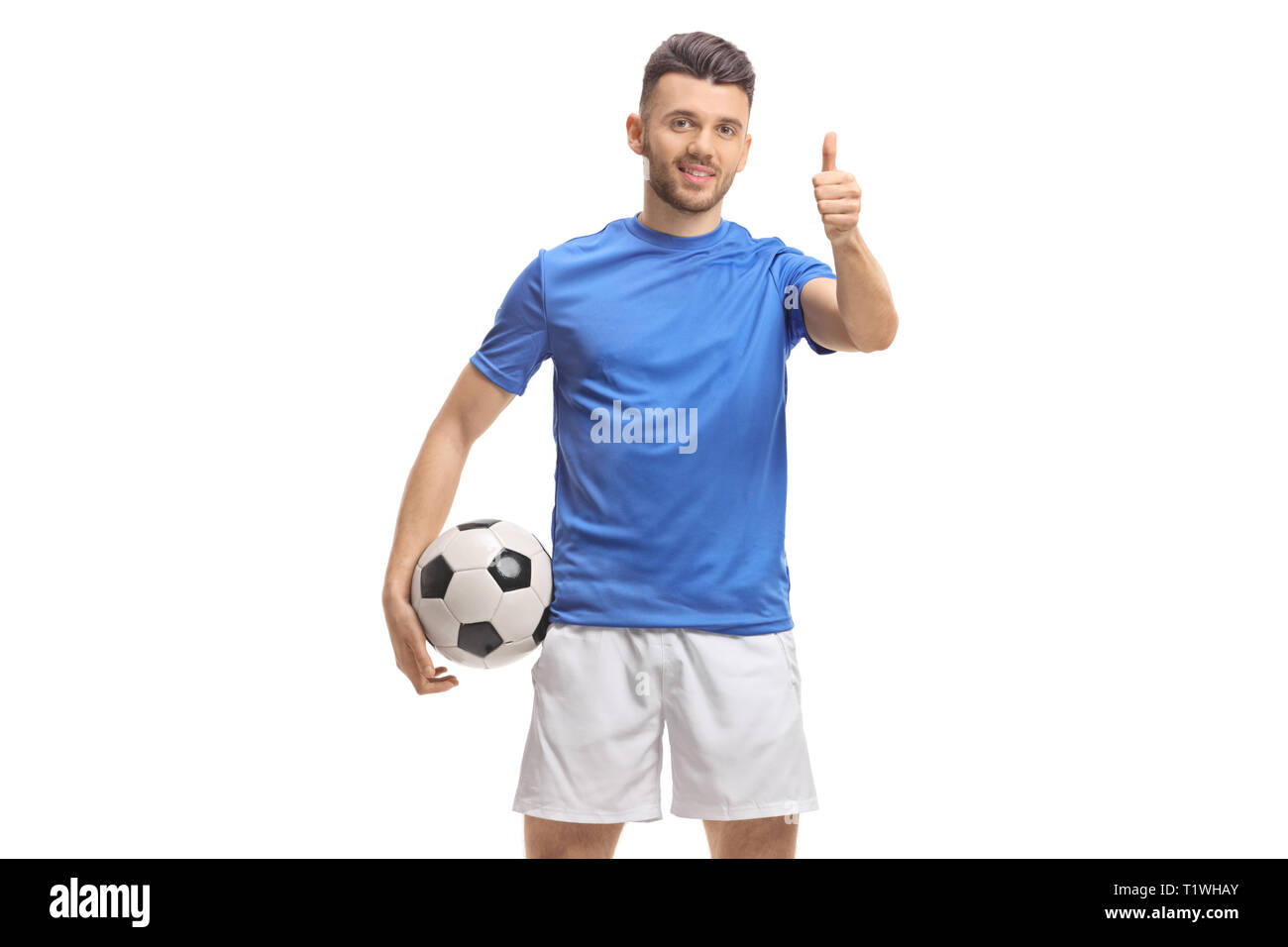 Giocatore di calcio tenendo un calcio e facendo un pollice in alto segno isolato su sfondo bianco Foto Stock