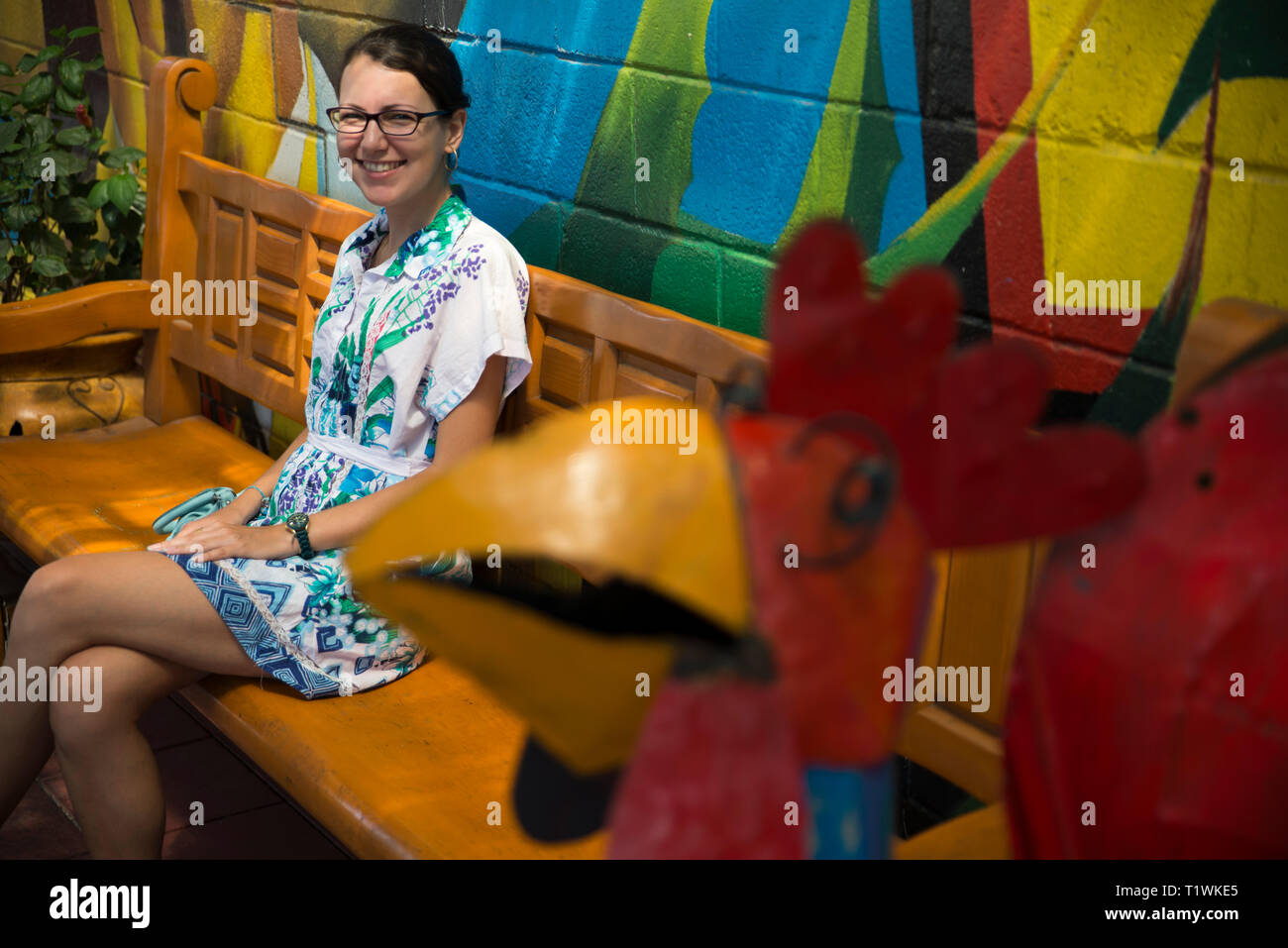 Donna che guarda in telecamera seduta con le gambe incrociate Foto Stock