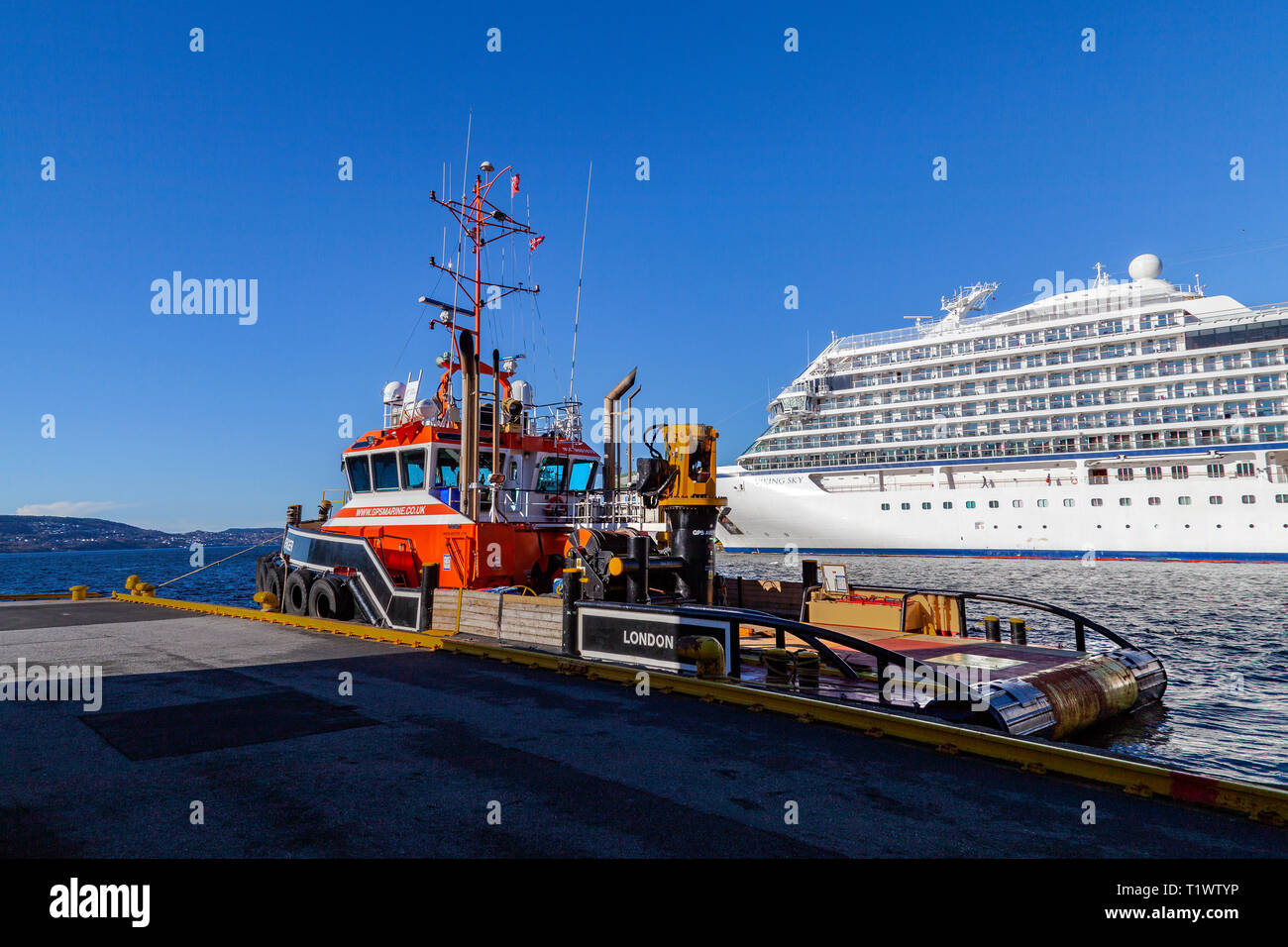 UK tug vendicatore GPS a Tollbodkaien quay a Bergen, Norvegia. In background, nave da crociera Viking Sky. Foto Stock