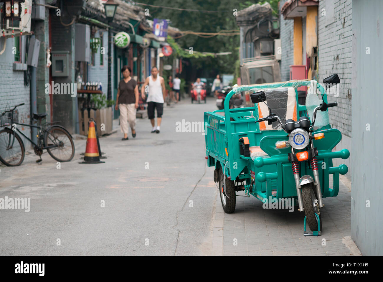 Pechino, Cina - 08 04 2016: un triciclo per adulti, in bicicletta con tre ruote in un hutong, in una strada di Pechino, Cina Foto Stock