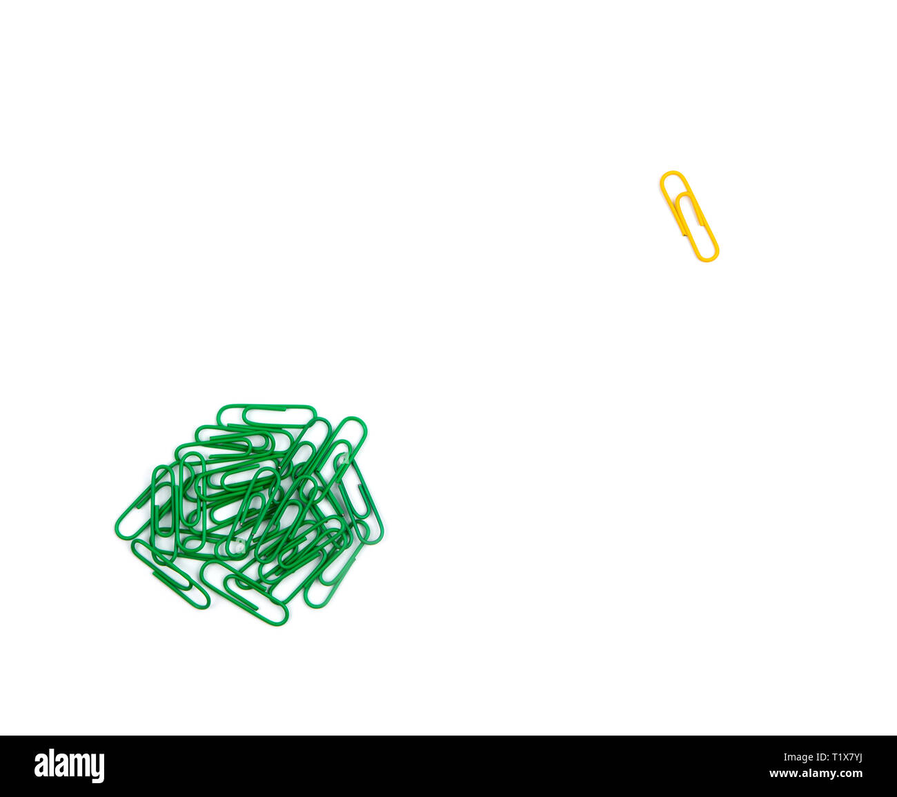 Illustrazione di unicità o solitudine. un gruppo di Libro verde clip nell'angolo in alto a sinistra e un solitario giallo clip di fermo sul lato destro su un w Foto Stock