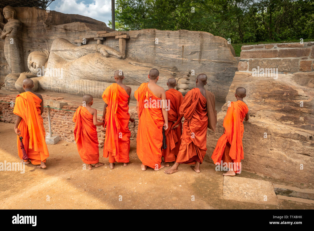Un gruppo di Buddisti visita il Gal Vihara Buddha Nirvana santuario in Polonnaruwa, Sri Lanka. Foto Stock