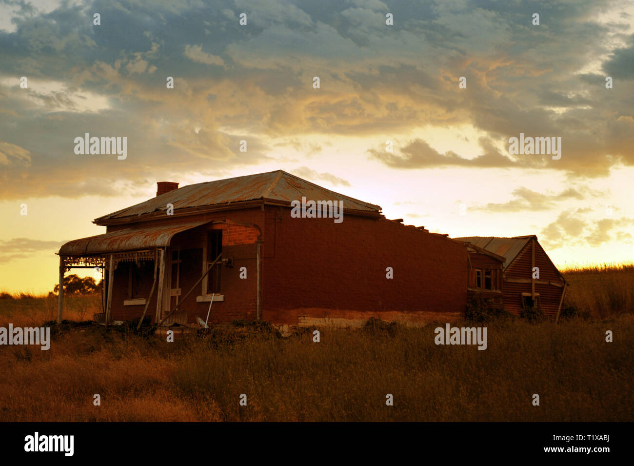 Vista al tramonto di un abbandonato ai primi del novecento ed weatherboard home nell'outback australiano. Foto Stock